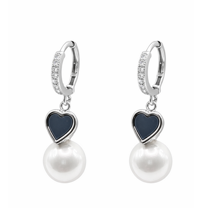 Pair of earrings with heart-shaped dark blue stones and pearl drops on a white background