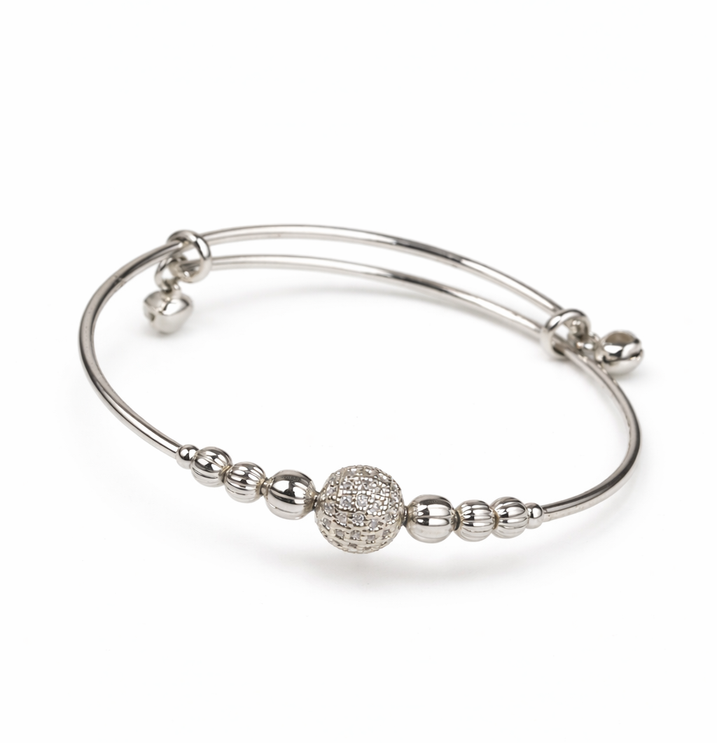 Silver bracelet with spherical charm on a white background