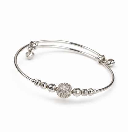 Silver bracelet with spherical charm on a white background
