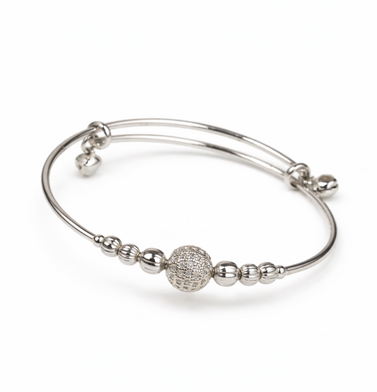 Silver bracelet with spherical charm on a white background