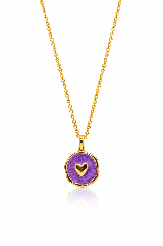 Gold necklace with a purple pendant featuring a heart design on a white background