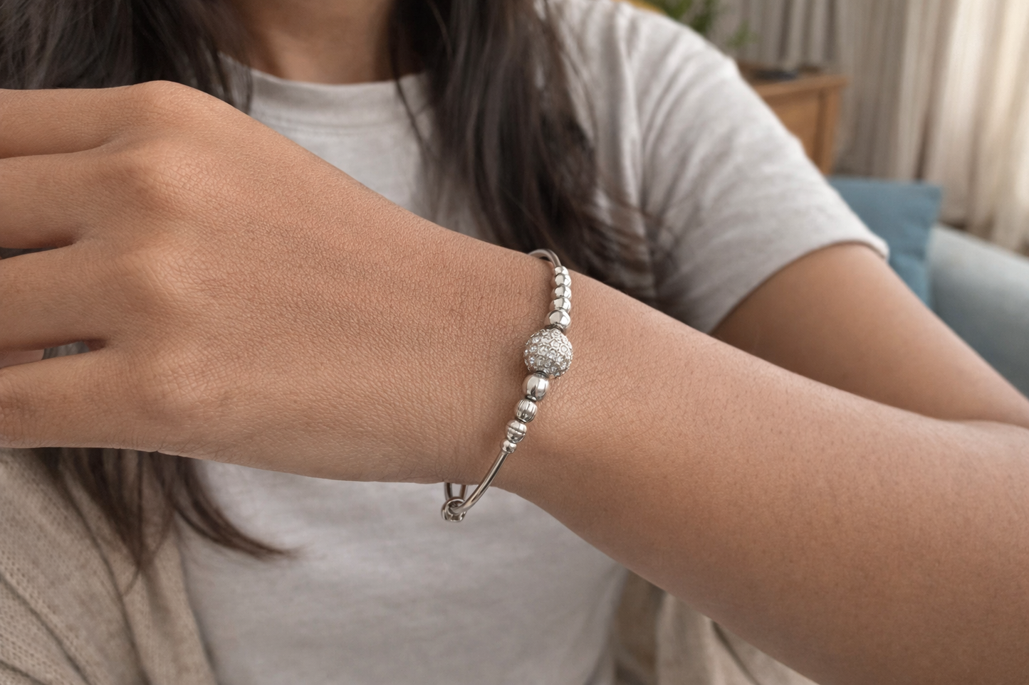 Silvona lady wearing a silver beaded bracelet on a neutral background