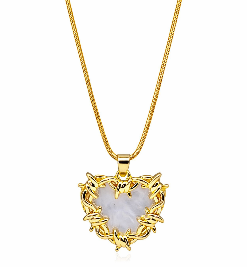 Gold heart-shaped pendant necklace with a white stone on a white background